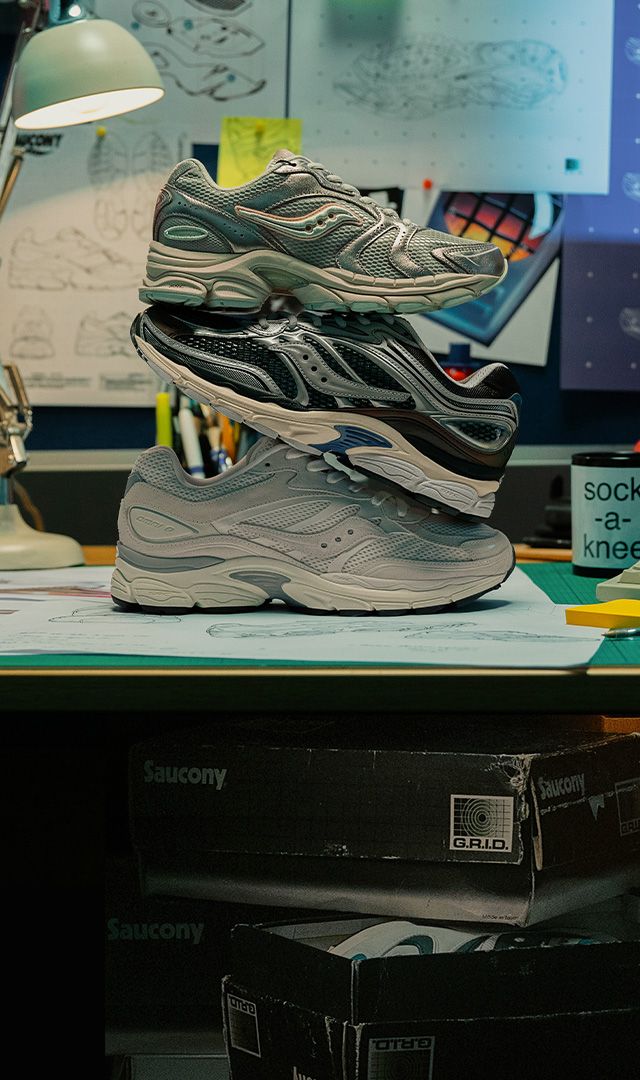 Retro Saucony shoes on a desk beside a black landline and an old computer.